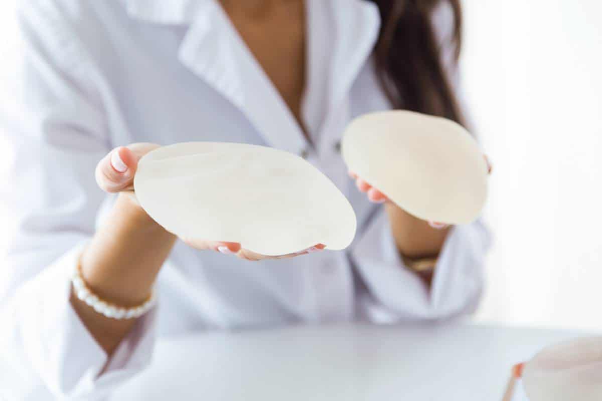 woman holding silicon breast implants