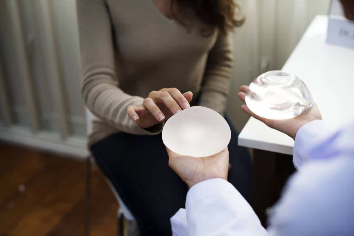 woman choosing between two breast implants