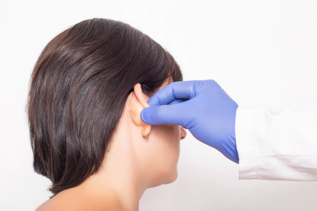 A plastic surgeon doctor examines a patient s girl's ears before performing an otoplasty surgery