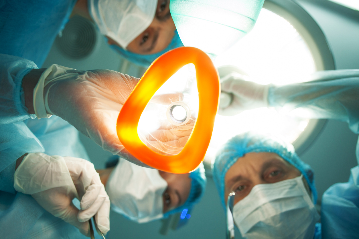 looking up from patient chair, doctors with masks about to apply general anesthesia mask