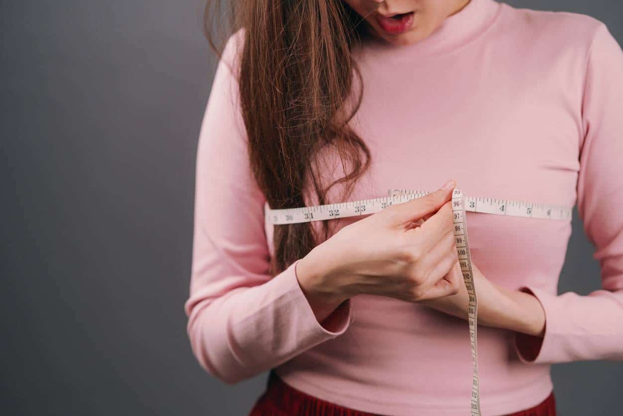 woman wrapping measuring tape around chest